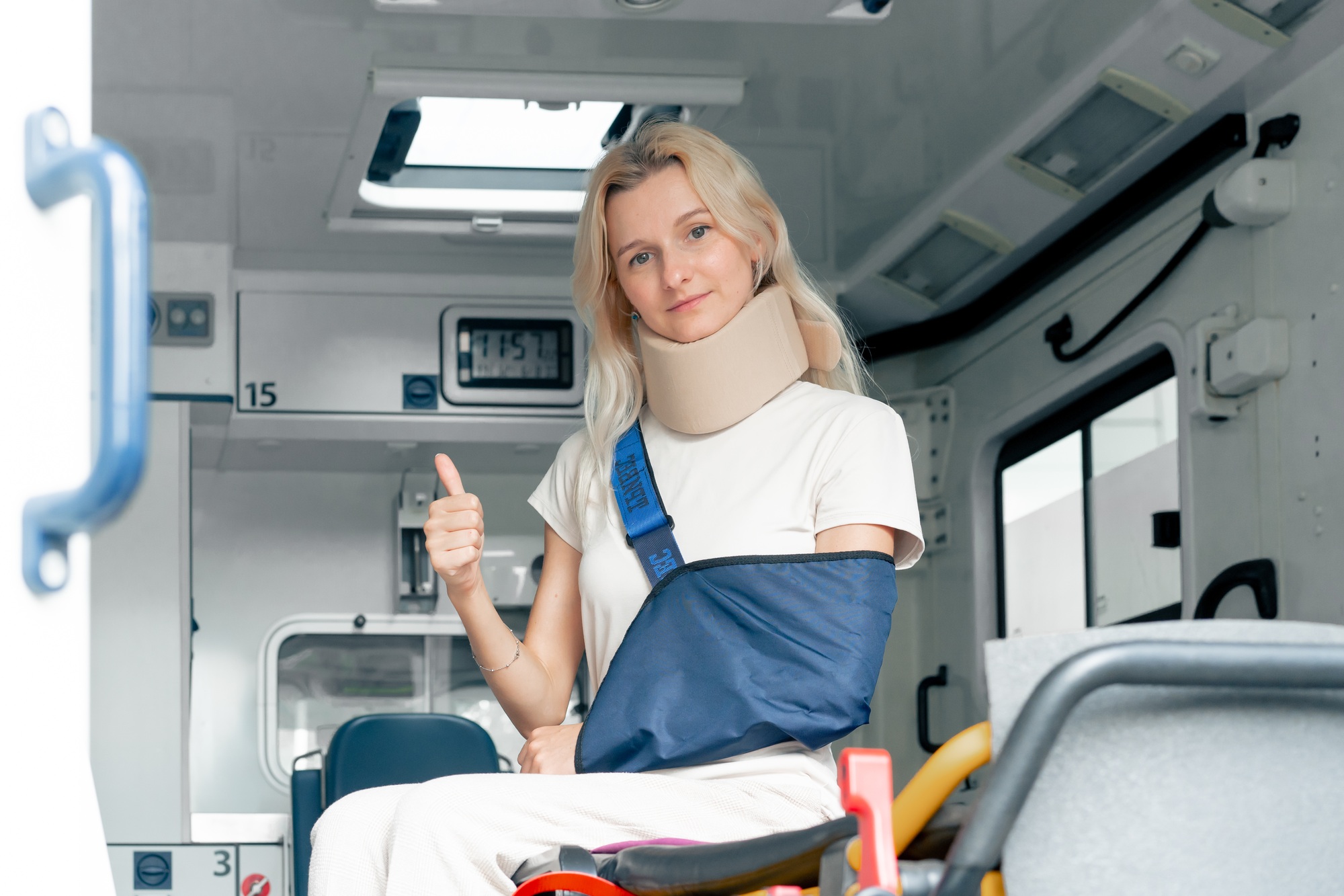 on the street in an ambulance a young patient with an injured neck and arm transporting the patient